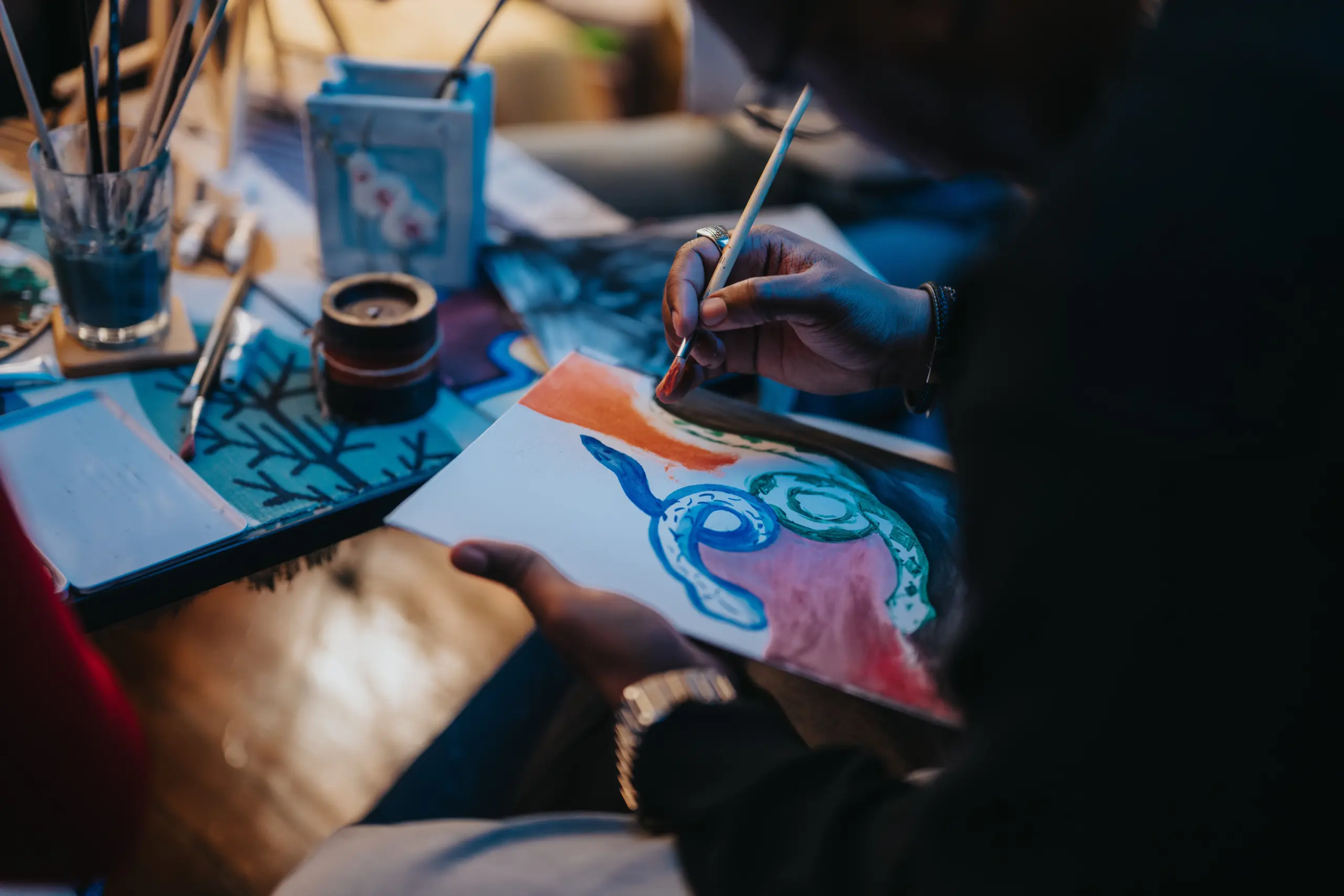 A close up shot of an artist painting colorful patterns on a canvas during an art session