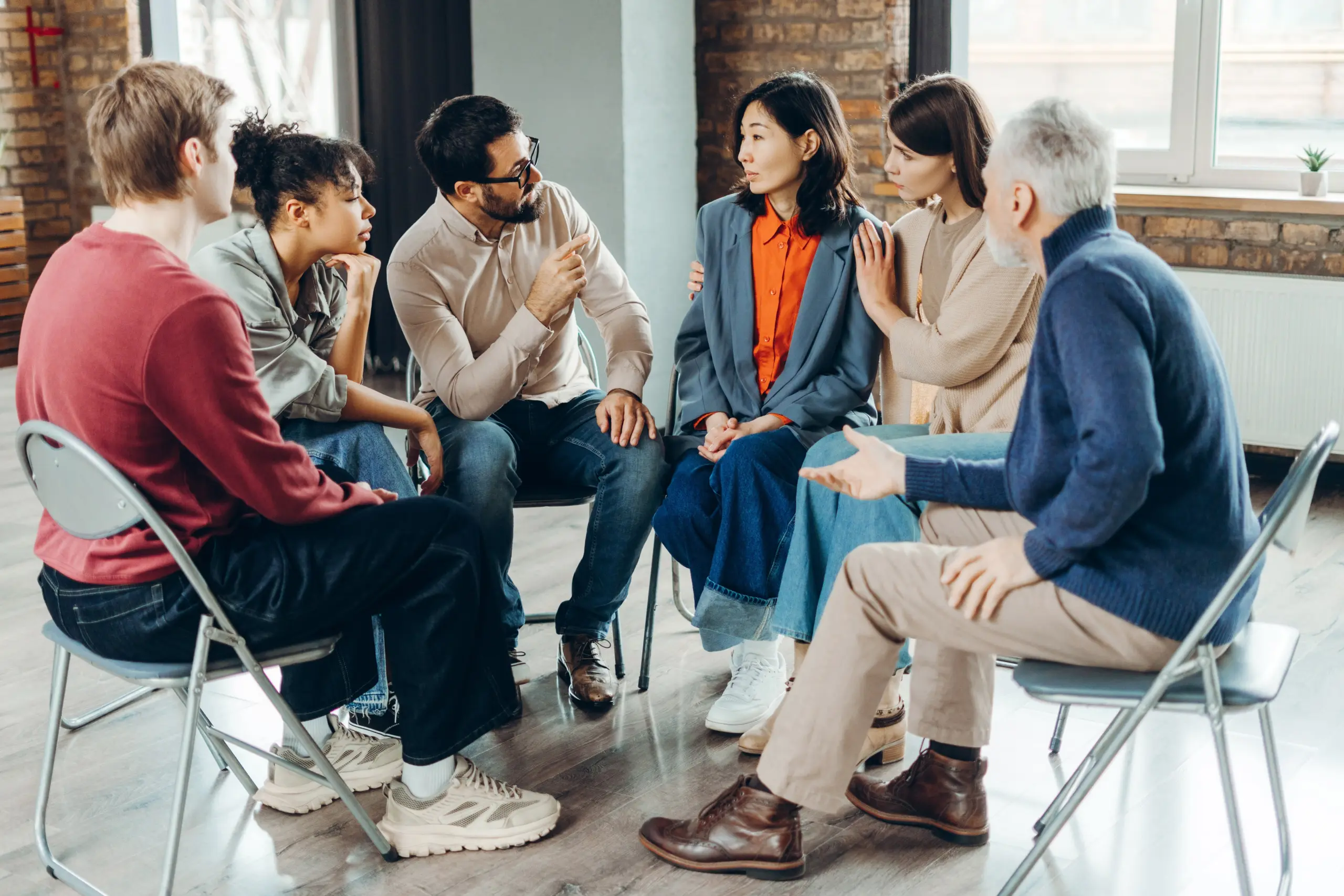 people in a group therapy setting supporting each other in recovery