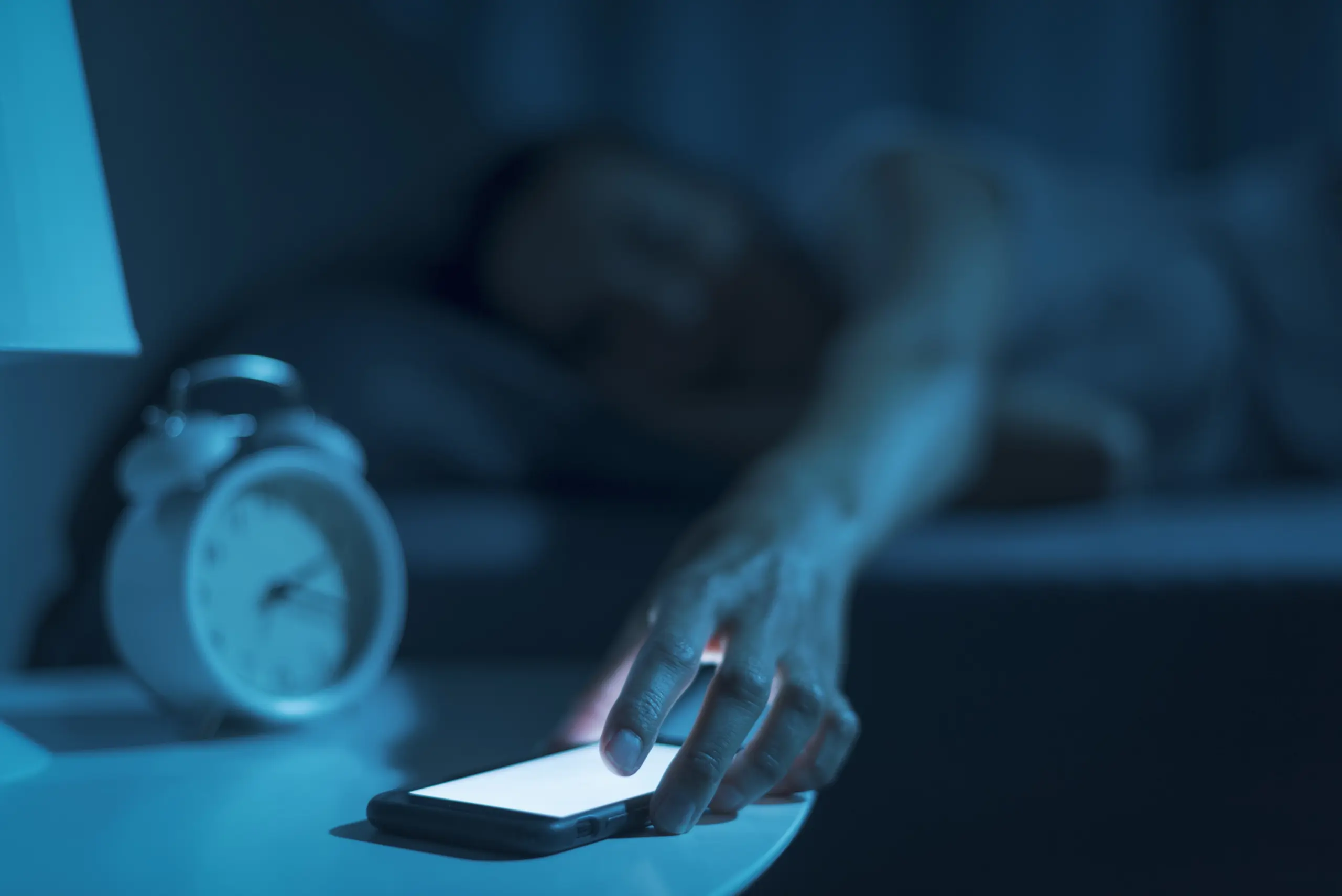 Individual overwhelmed by social media and addiction late at night